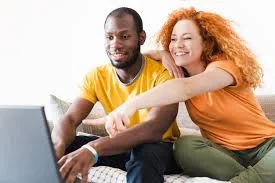 un homme et une femme qui montre un ordinateur portable