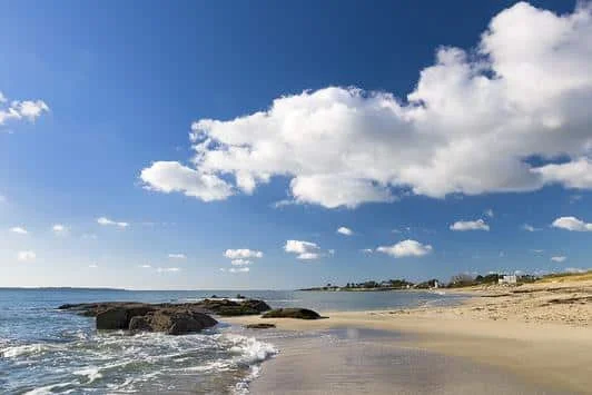 plage de sable blanc avec quelques rochers