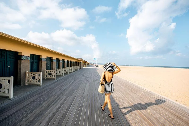 une femme marche sur les marches de deauville en normandie