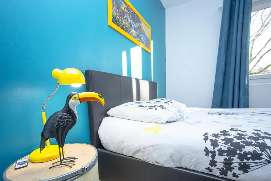 un lit avec un toucan en premier plan